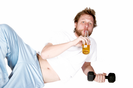 A man lifting weights while drinking beer.